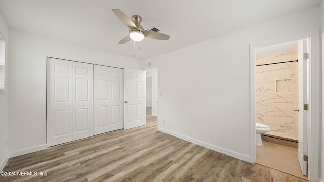 unfurnished bedroom with connected bathroom, ceiling fan, a closet, and light wood-type flooring