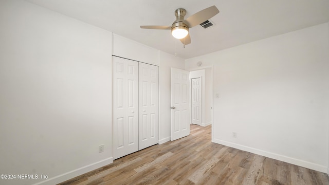 unfurnished bedroom featuring ceiling fan, light hardwood / wood-style floors, and a closet