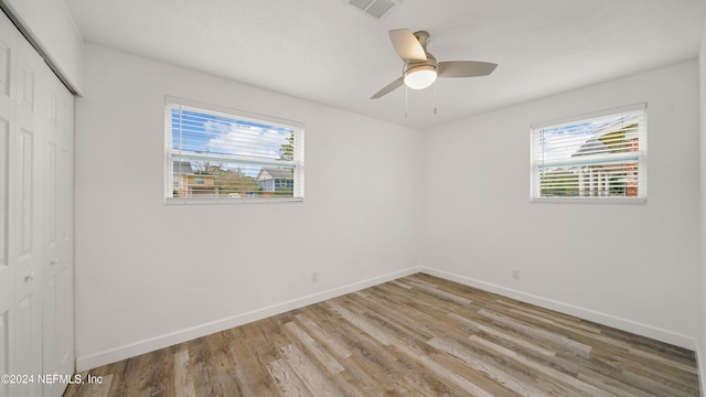 unfurnished bedroom featuring hardwood / wood-style flooring, a closet, and ceiling fan