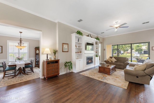 living room featuring dark hardwood / wood-style floors, ceiling fan, and crown molding