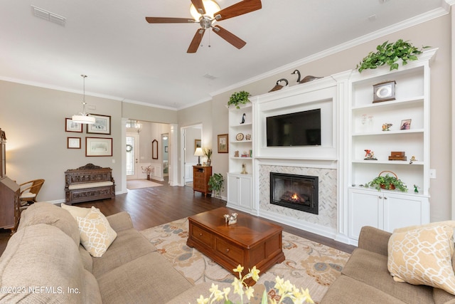 living room featuring a high end fireplace, hardwood / wood-style floors, ceiling fan, and crown molding