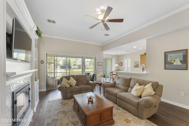 living room featuring hardwood / wood-style flooring, ceiling fan, ornamental molding, and a premium fireplace