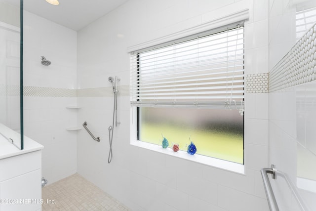 bathroom with a tile shower and plenty of natural light