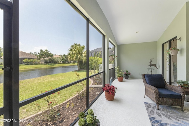 sunroom featuring a water view and lofted ceiling