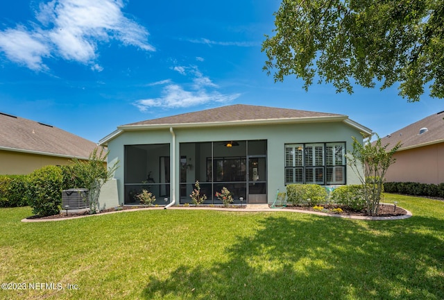 back of house with a sunroom, a yard, and central AC