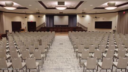 cinema featuring crown molding, a tray ceiling, and ceiling fan