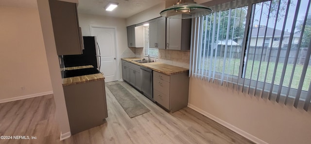 kitchen with gray cabinets, sink, stainless steel dishwasher, and light hardwood / wood-style floors