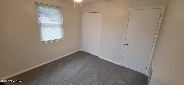 unfurnished bedroom with dark colored carpet