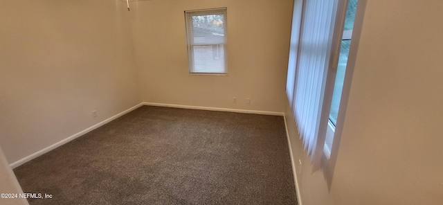 empty room featuring dark carpet