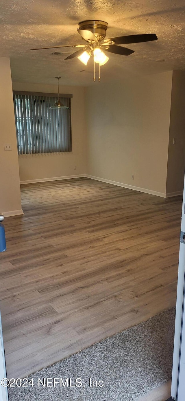 unfurnished room featuring a textured ceiling and hardwood / wood-style flooring