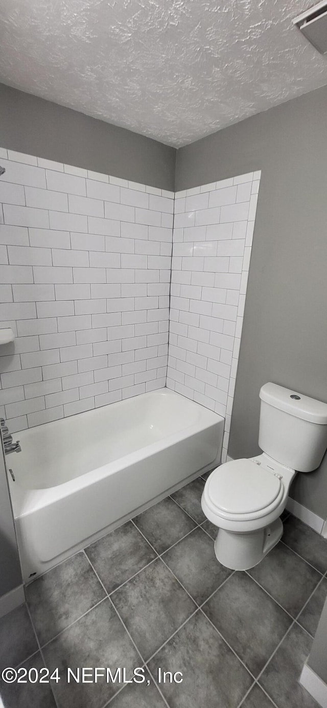 bathroom featuring tile patterned flooring, toilet, and a textured ceiling