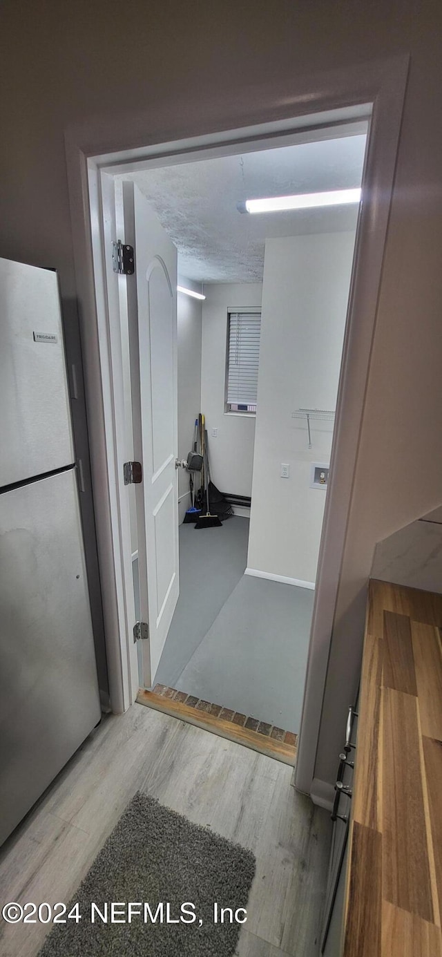 corridor featuring wood-type flooring and a textured ceiling