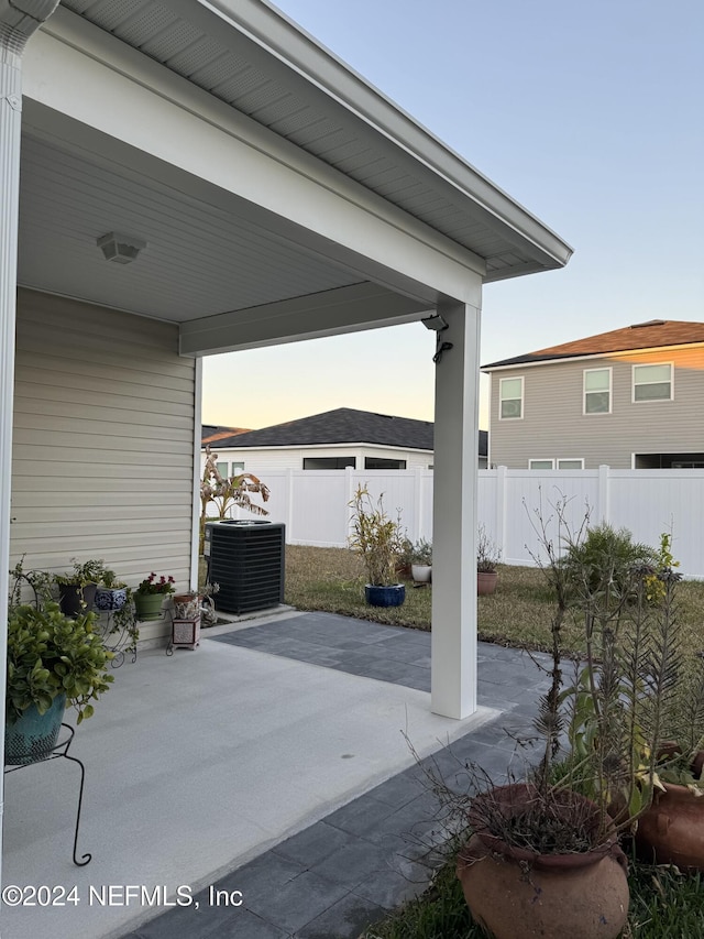 patio terrace at dusk featuring central AC