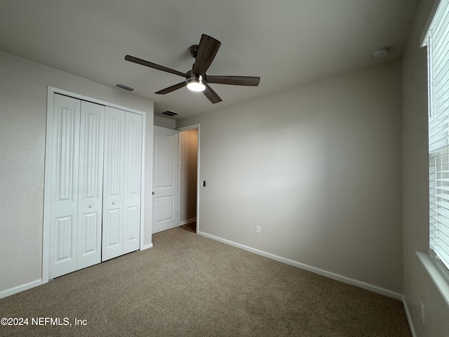 unfurnished bedroom featuring a closet, ceiling fan, and carpet