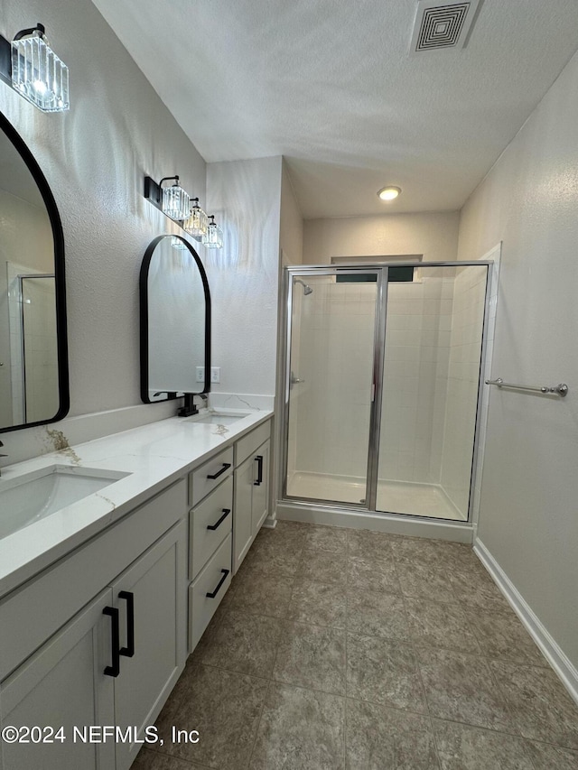 bathroom with an enclosed shower, a textured ceiling, and vanity