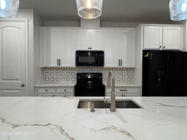 kitchen with black appliances, hanging light fixtures, light stone counters, decorative backsplash, and white cabinetry