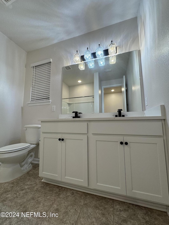 bathroom featuring toilet, a textured ceiling, and vanity