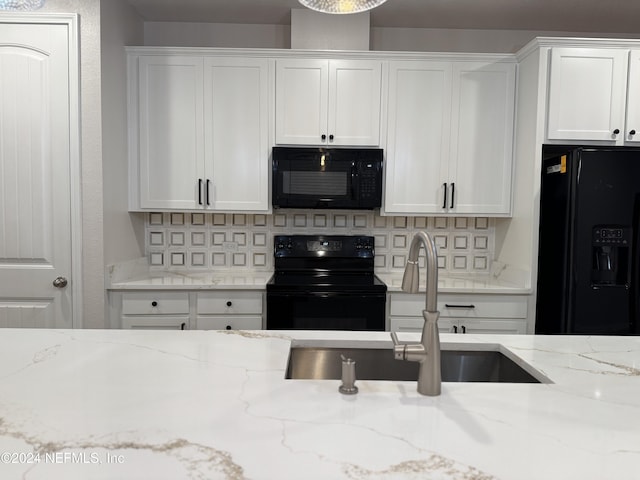 kitchen featuring sink, decorative backsplash, black appliances, and white cabinetry