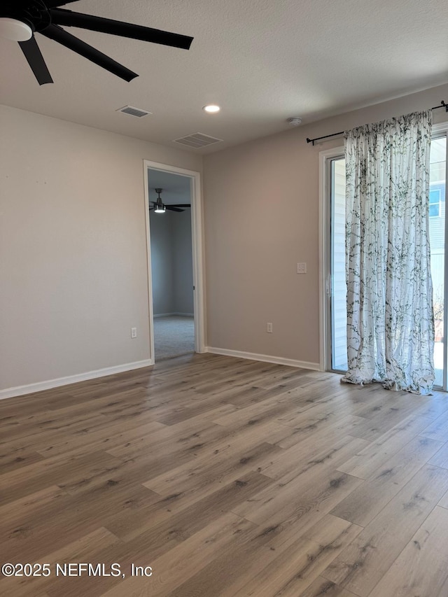 empty room featuring ceiling fan and hardwood / wood-style floors