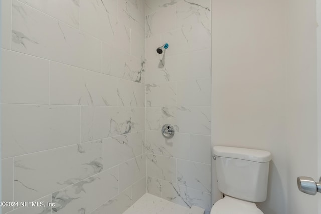 bathroom with tiled shower and toilet