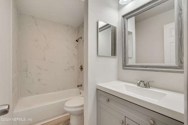 full bathroom featuring vanity, tiled shower / bath combo, and toilet