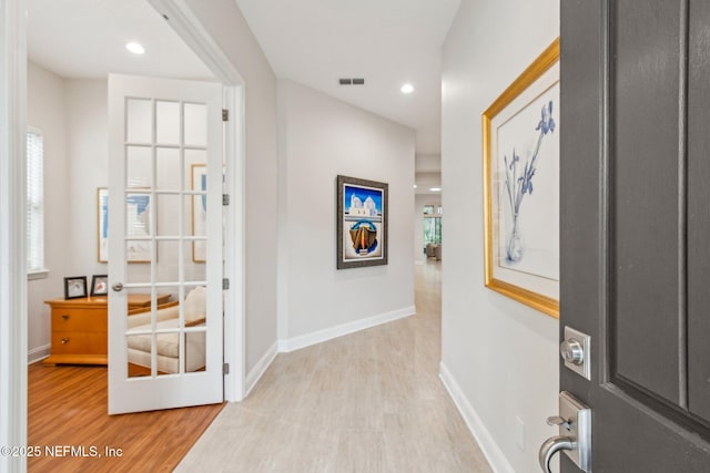 foyer with light hardwood / wood-style floors and french doors