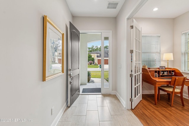 entrance foyer with light tile patterned floors and french doors