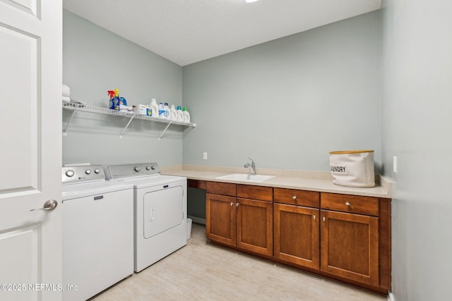 laundry room featuring washer and clothes dryer, cabinets, and sink