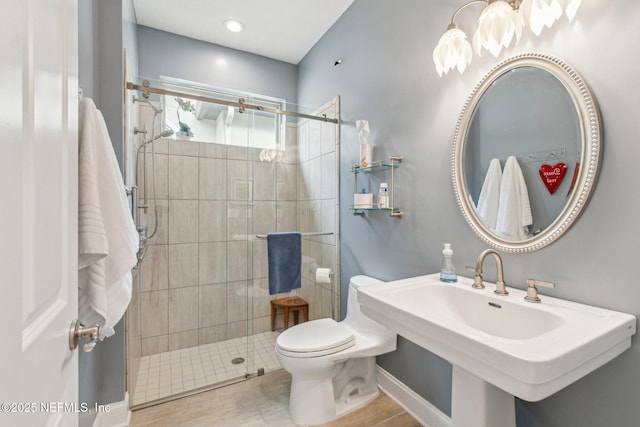 bathroom with walk in shower, sink, and toilet