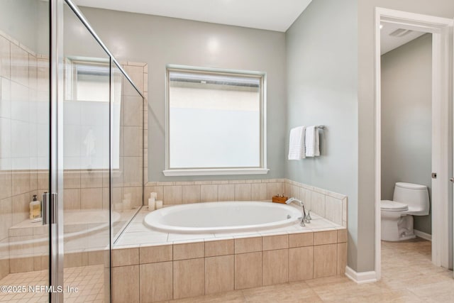 bathroom with tile patterned flooring, shower with separate bathtub, toilet, and a wealth of natural light