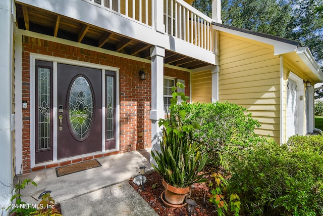 property entrance featuring a garage and a balcony