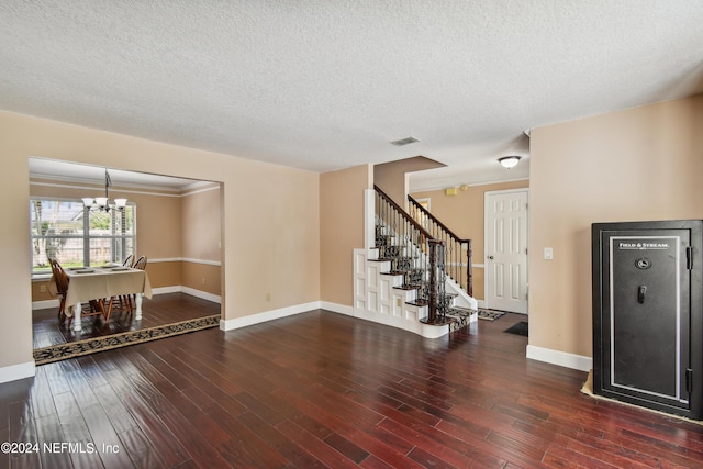 unfurnished room featuring a textured ceiling, dark hardwood / wood-style floors, and a notable chandelier