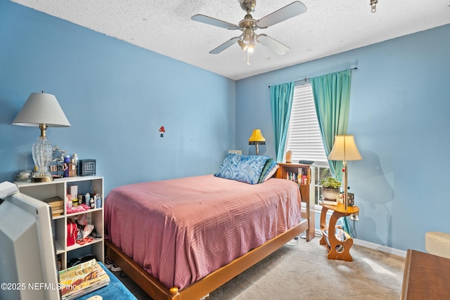 carpeted bedroom featuring ceiling fan and a textured ceiling