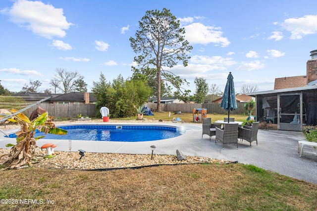 view of swimming pool with a yard, a patio area, and a sunroom