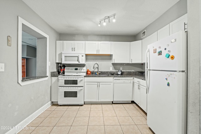 kitchen with white appliances, sink, light tile patterned floors, a textured ceiling, and white cabinetry