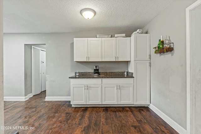 kitchen featuring white cabinets, dark wood-type flooring, and a textured ceiling