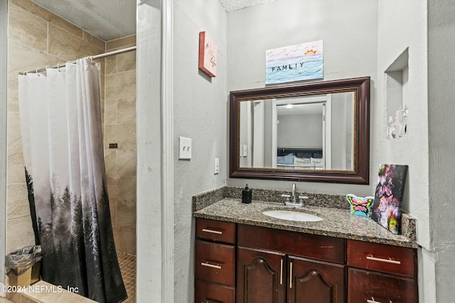 bathroom with curtained shower, vanity, and a textured ceiling