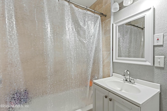 bathroom featuring vanity and shower / tub combo with curtain