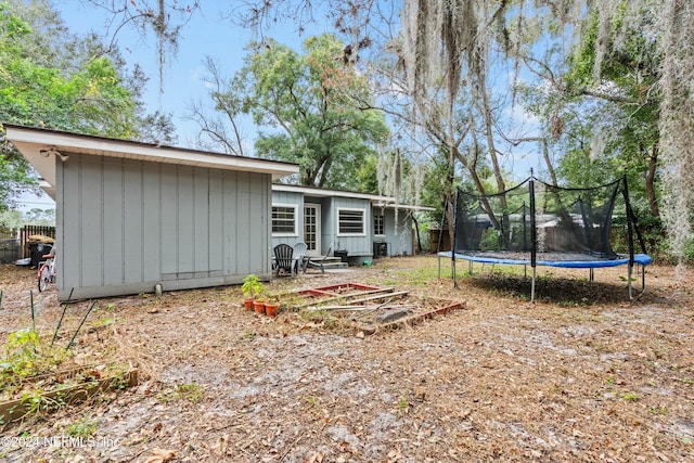 back of property featuring a trampoline