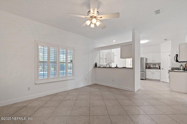 unfurnished living room with light tile patterned floors and ceiling fan