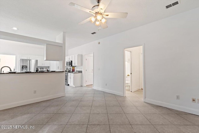 unfurnished living room with sink, ceiling fan, and light tile patterned flooring