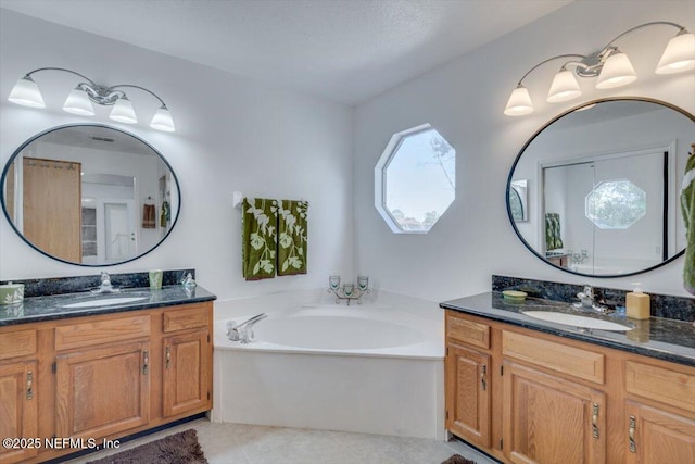 bathroom with vanity and a bath