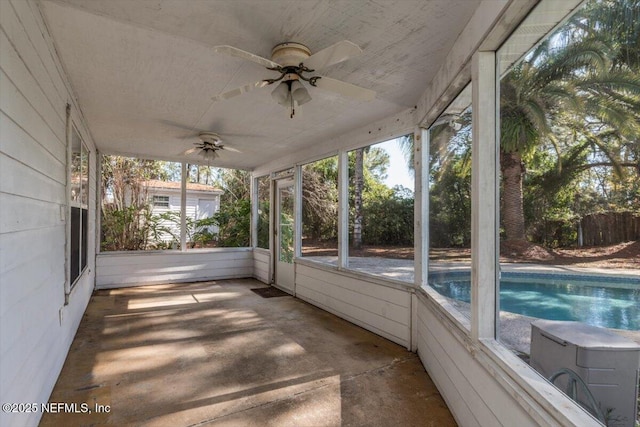 unfurnished sunroom with ceiling fan