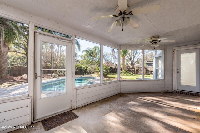 unfurnished sunroom with ceiling fan