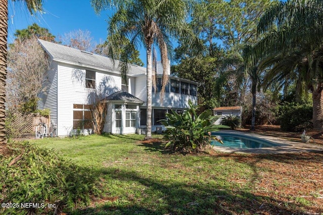 back of property featuring a lawn and a sunroom