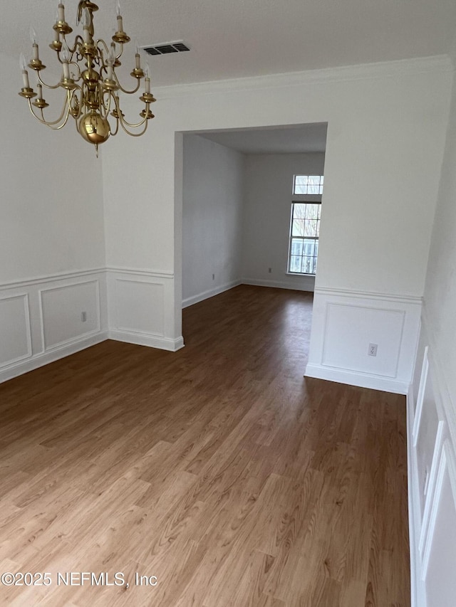 2305 Locustwood Ct, Orange Park, FL 32065 - spare room featuring a decorative wall, a chandelier, ornamental molding, light wood finished floors, and a wainscoted wall