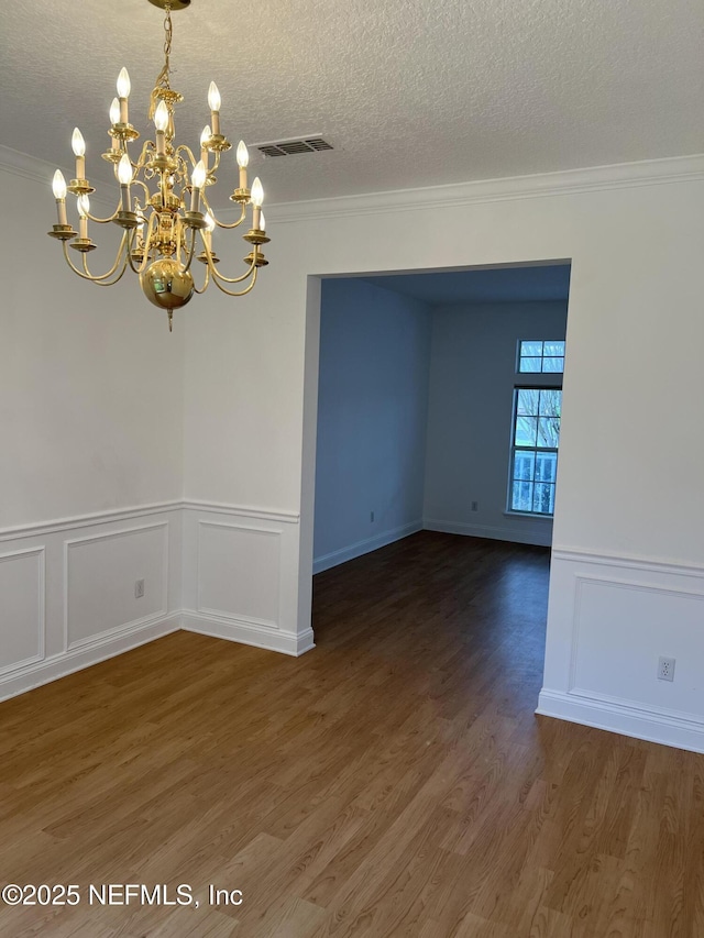 2305 Locustwood Ct, Orange Park, FL 32065 - unfurnished room featuring crown molding, a chandelier, wood finished floors, a textured ceiling, and wainscoting
