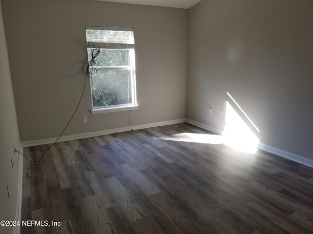 empty room featuring dark hardwood / wood-style flooring and a healthy amount of sunlight