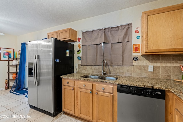 kitchen with light stone counters, sink, a textured ceiling, and appliances with stainless steel finishes