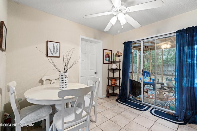 tiled dining space with ceiling fan and a textured ceiling